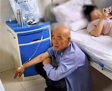 老人蹲在地上打点滴 孙女躺病床玩手机（